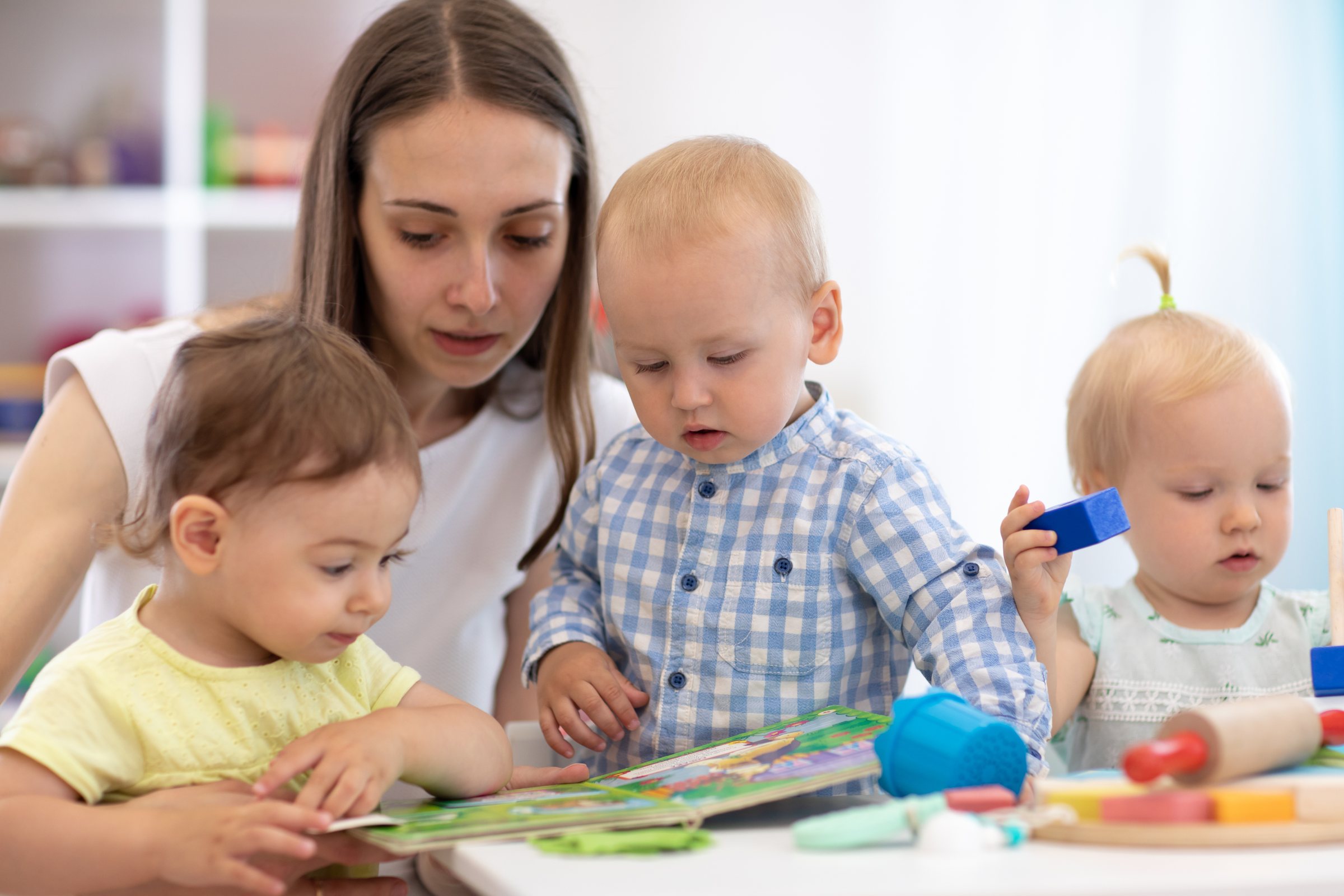 Educator reading a picture book with toddlers