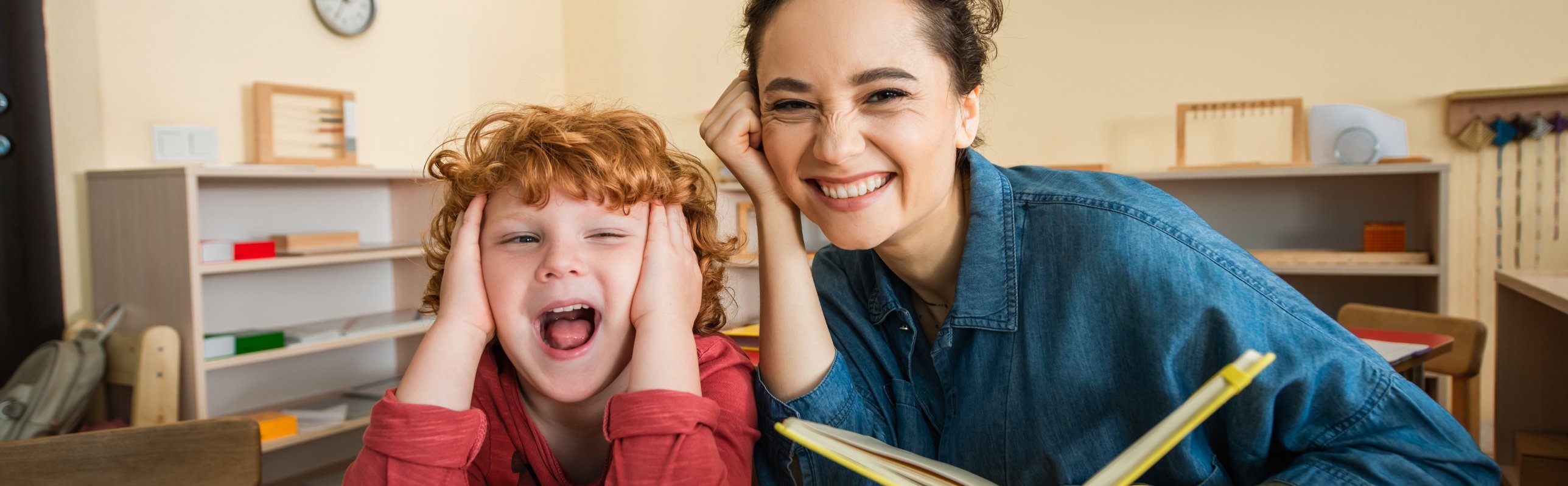 Kidsville educator laughing with a child in a Montessori classroom
